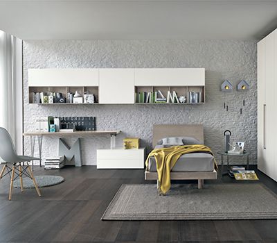 Habitación juvenil en tonos blancos y madera color tabaco; con mesa de estudio, mesita de dos cajones y mueble-librería colgado.