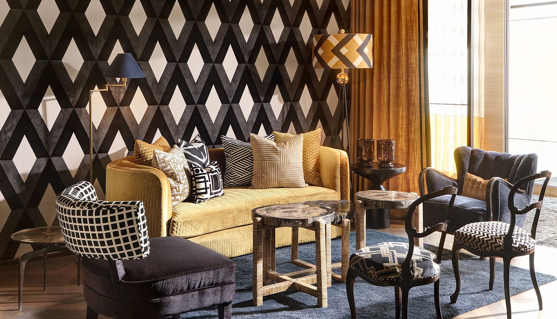 Combinación de papel pintado en rombos negro y textiles en sofá y sillones de diferentes tonos y telas.